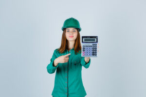 a woman in a hard hat holding a calculator